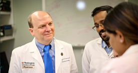 Rodney Newberry, MD (left), a gastroenterologist, talks in his lab with postdoctoral research associates (from left) Sreeram Udayan, PhD, and Vini John, PhD. Newberry has been named a William H. Danforth Washington University Physician-Scientist Scholar.